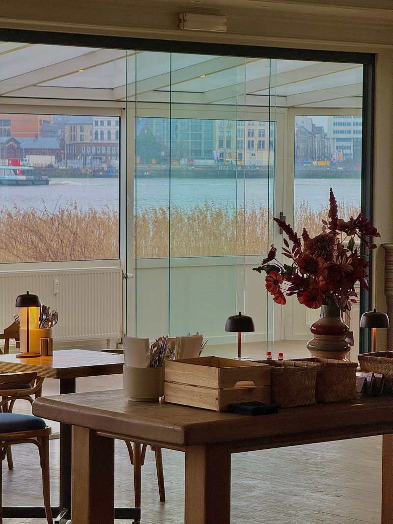 Het interieur van Liberty met grote ramen die uitkijken op het water